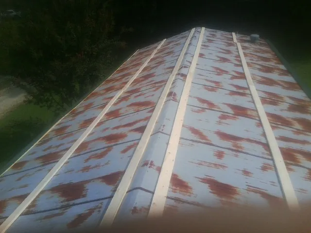 Rusted metal roof panels with new wood purlins before replacement — Storm Damage Roof Repair in Butte City by Roofing Brothers