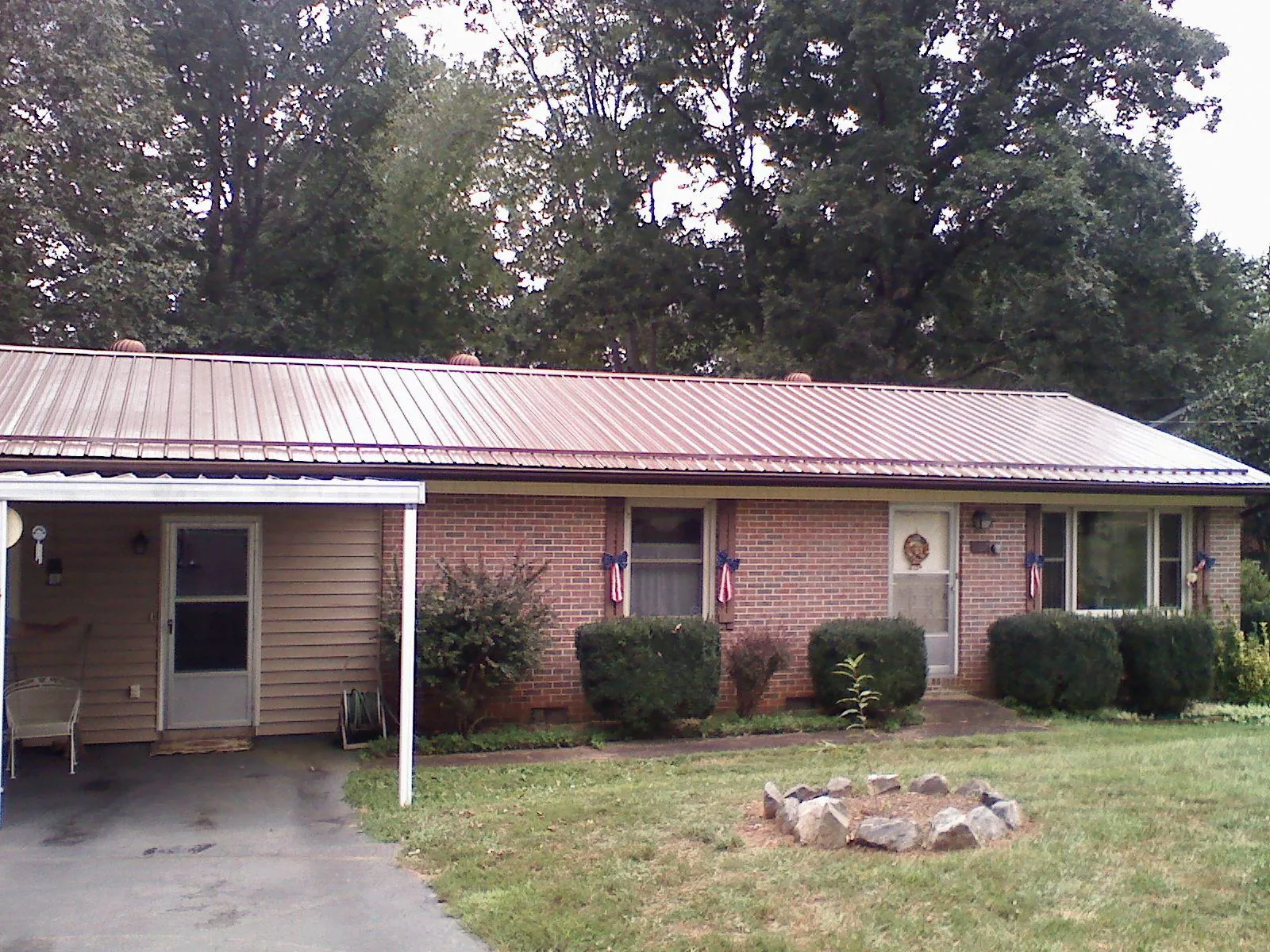 Bronze metal roof and carport on a brick ranch home — Roof Repair work by our crew in Butte City